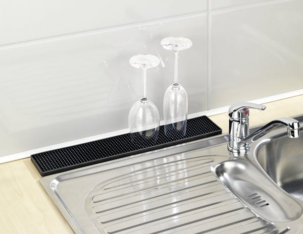 Un tapis égouttoir fin à placer entre le mur du plan de travail et l'évier pour faire sécher et égoutter des verres, une planche à découper, des éponges...