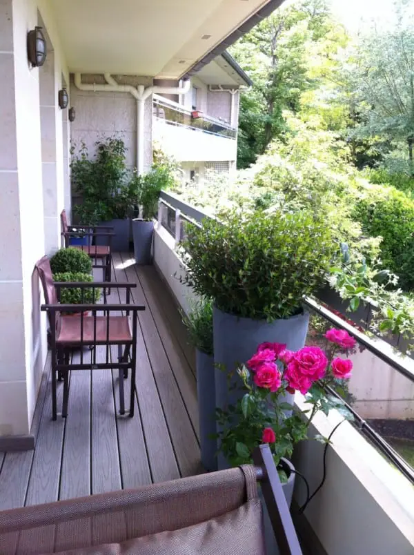 Un balcon tout en longueur, aménagé avec différentes zones (repas, détente, jardinage,...)