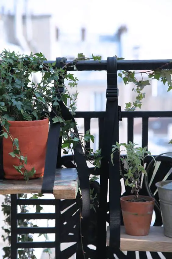 Les brettelles de balcon Bacsac et une planche en bois pour fabriquer une petite étagère suspendue, une bonne idée à retenir pour aménager un petit balcon urbain