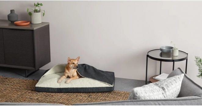 Un lit rembourré avec une partie couverture effet peau de mouton pour assurer à votre toutou des douces nuits