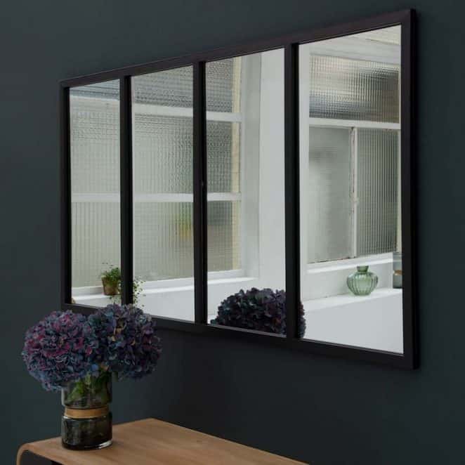 Installé de façon judicieuse face à une baie vitrée ou une grande fenêtre, le miroir verrière crée un effet trompe-l’oeil qui agrandit votre salon