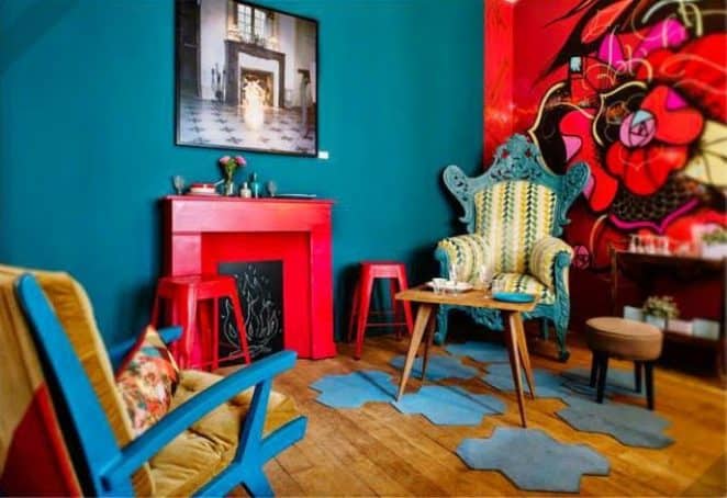 Mettre en valeur la cheminée avec un colori orange / coquelicot posée sur un mur bleu turquoise. Le mur opposé reprend le code inverse : un mur coquelicot avec des détails bleu turquoise
