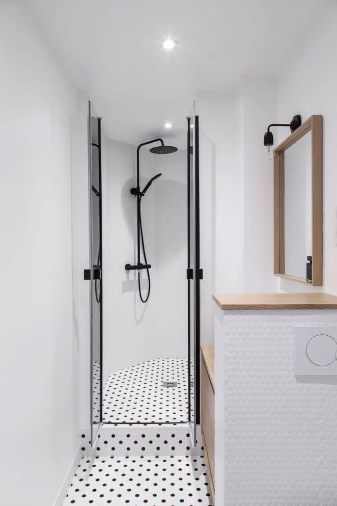 A small white bathroom with a cabochon floor covering in a retro style