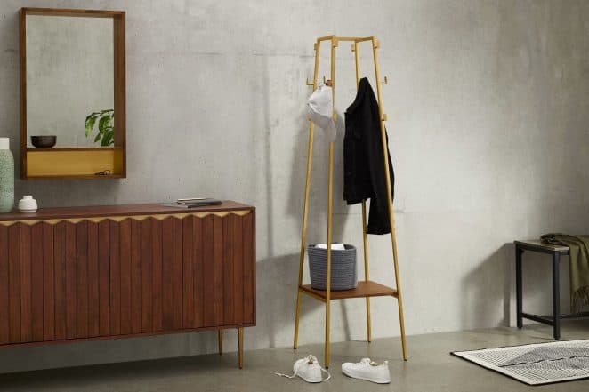 Ce grand porte-manteau est composé de bois de manguier et de laiton. Il possède plusieurs crochets et une petite étagère