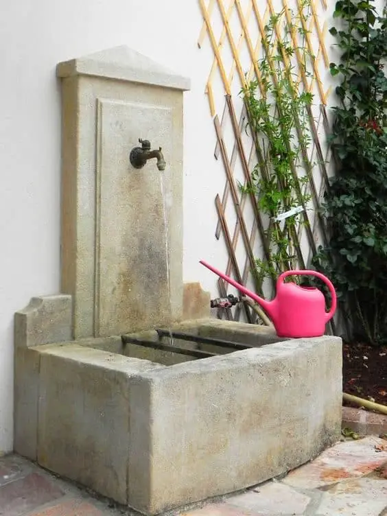 Quelques miroirs en rotin et une jolie applique boho habillent ce mur de jardin blanc, très simple