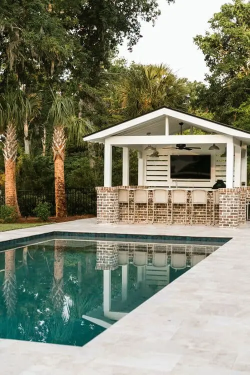 Une maison de piscine avec un bar en pierre