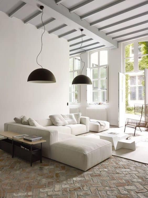 Ce grand canapé blanc au style imposant permet de séparer visuellement le salon en deux