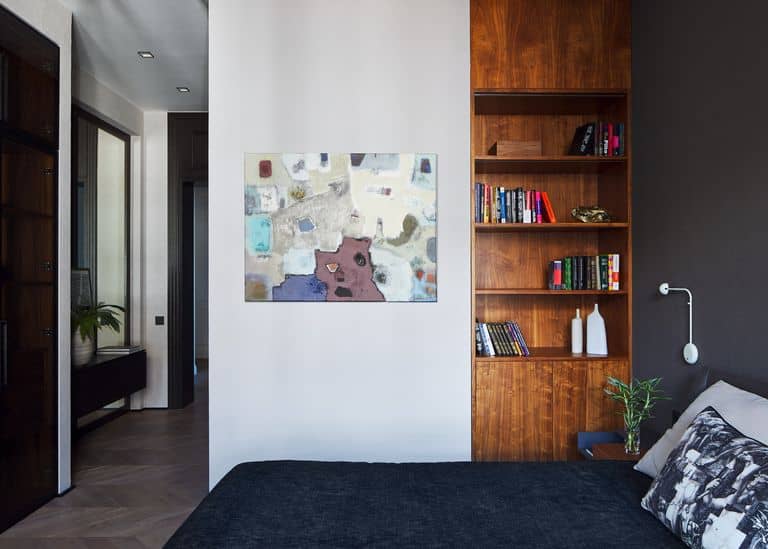 Une harmonie de teintes avec un tableau art moderne, une bibliothèque boisée et un mur gris anthracite