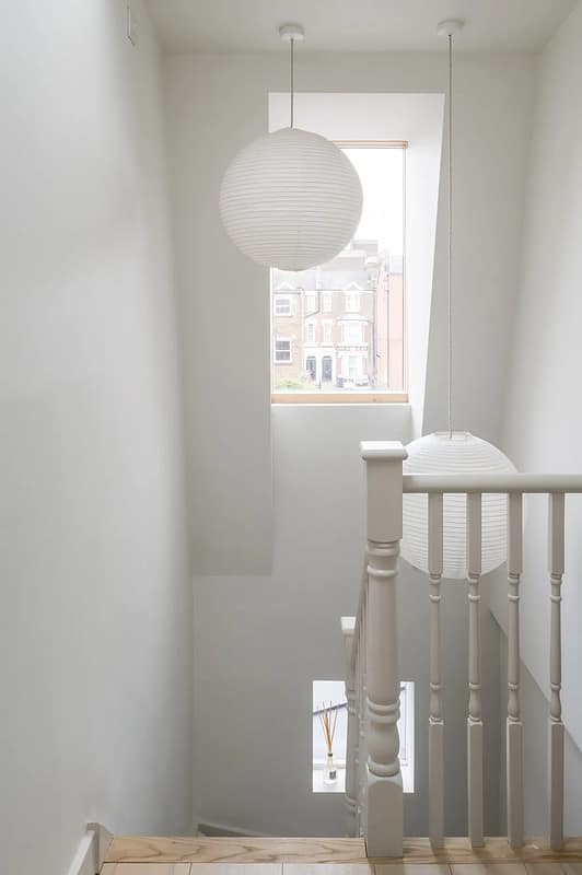 Une suspension blanche simple pour cette montée d'escalier immaculée